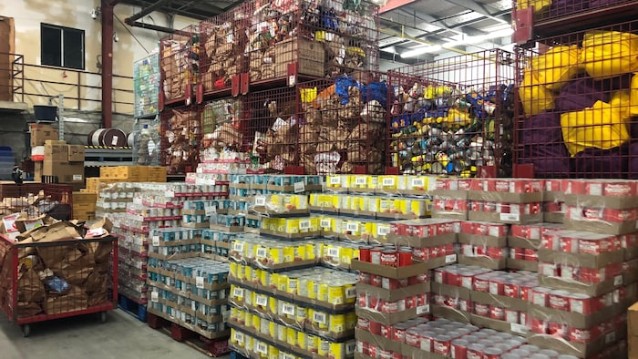 Des tonnes de boîtes de conserve et de sacs d'aliments empilés dans l'ancien entrepôt de la Banque d'alimentation d'Ottawa, en 2020.