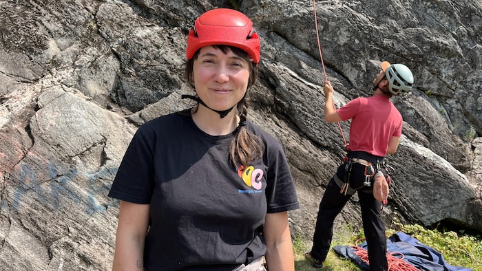 Camille Robidoux-Daigneault fait face à la caméra. Elle est en plein activité d'escalade extérieure. Quelqu'un assure derrière elle.