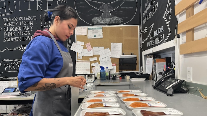 Selena Montes Alvarado colle des étiquettes sur des emballages de poisson.
