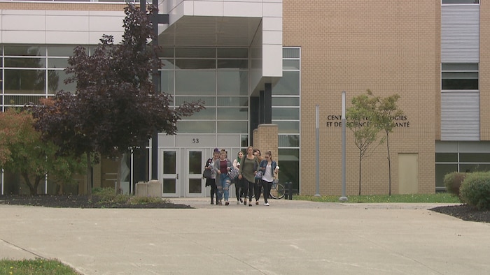 Des étudiants sortent d'un édifice.