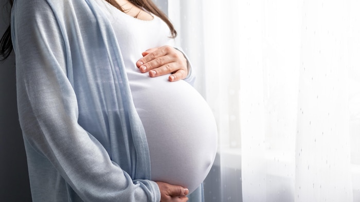 La femme enceinte se tient le ventre.
