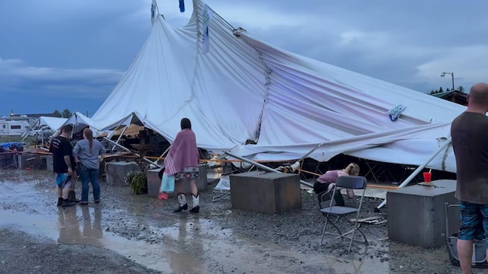 Un chapiteau de festival effondré au sol.