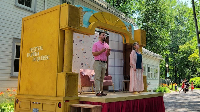 Deux chanteurs d'opéra en spectacle sur une scène mobile en extérieur.