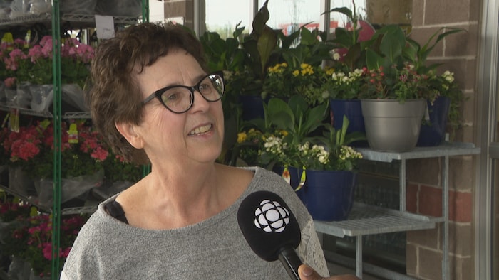 Francine Belliveau répond à des questions devant une épicerie.