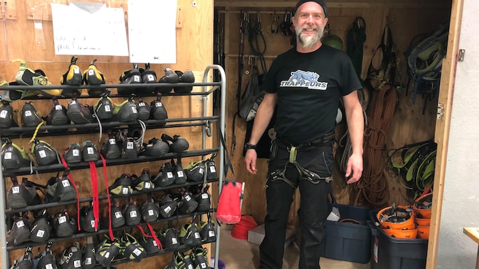 Fred Fournier, co-propriétaire de l'entreprise Attitude nordique, dans un local avec des souliers d'escalade