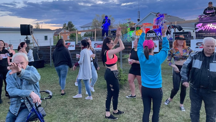 Une foule de personnes danse devant la scène d'un festival.