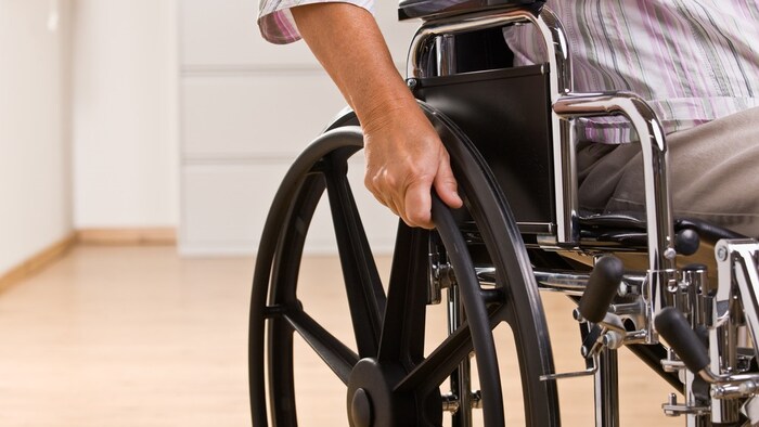 Une homme dans un fauteuil roulant.