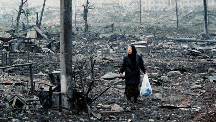 Une Tchétchène regarde un marché de Grozny détruit par les bombardements russes, en février 2000.
