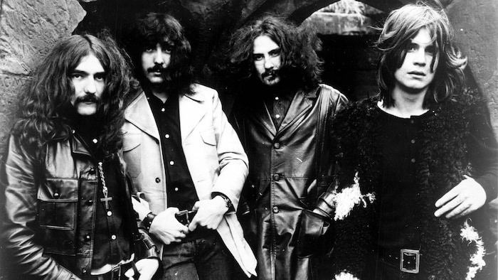 Geezer Butler, Tony Iommi, Bill Ward et Ozzy Osbourne du groupe Black Sabbath sont debout.