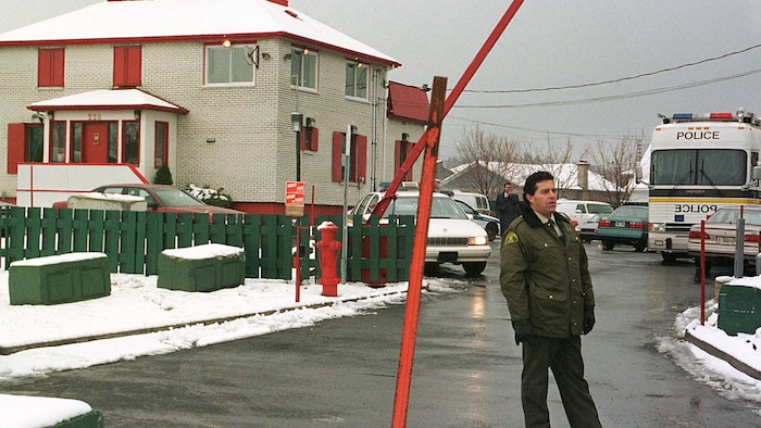 Un officier de la Sûreté du Québec se trouve devant le repère des Hells Angels à Saint-Nicolas, le 21 novembre 1997.