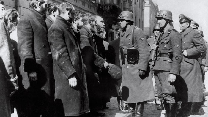 Des SS interrogent des habitants du ghetto de Varsovie en 1943.