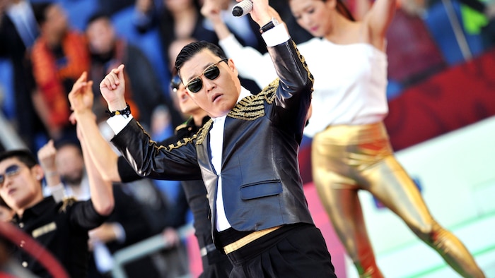 Le chanteur Psy danse en costume de scène.