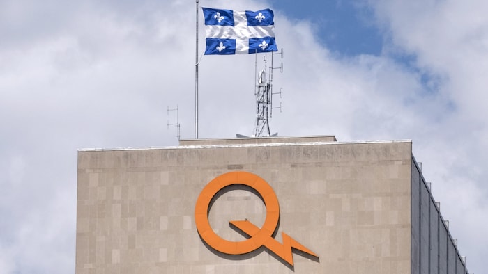 Le siège social d'Hydro-Québec, avec le logo de la société d'État et un drapeau du Québec sur le toit.