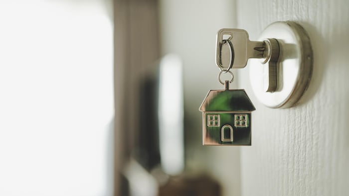 Photo d'une serrure avec une clé et une maison en porte-clés.