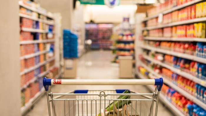 Un chariot dans une allée d'épicerie.
