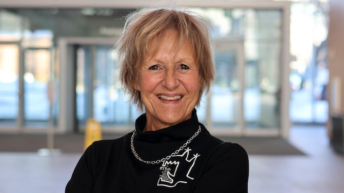 Les bras croisés, Lorraine Pintal sourit dans l'atrium de Radio-Canada.