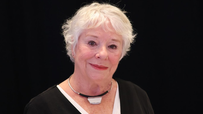Marie Eykel est devant un rideau noir.