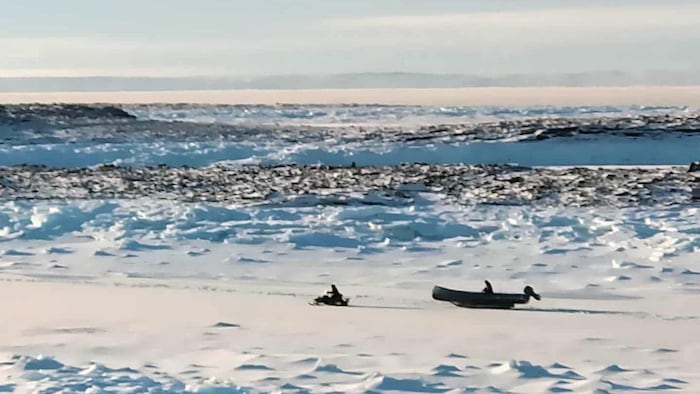 Une personne en motoneige au loin.