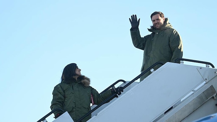 J.D. Vance en train de saluer de la main et de sourire en sortant de l'avion.