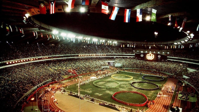 Les anneaux olympiques sont dessinés par des personnes dans le Stade olympique.