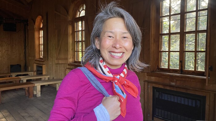 Kim Thúy sourit pour la photo. Elle se trouve dans la reconstitution d'une chapelle d'un poste de traite au Vieux-Poste de Sept-Îles.