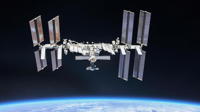 La Station spatiale internationale en orbite dans l'espace, au-dessus de l'horizon terrestre.