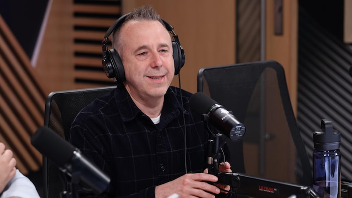 Laurent Dubois sourit derrière un micro.