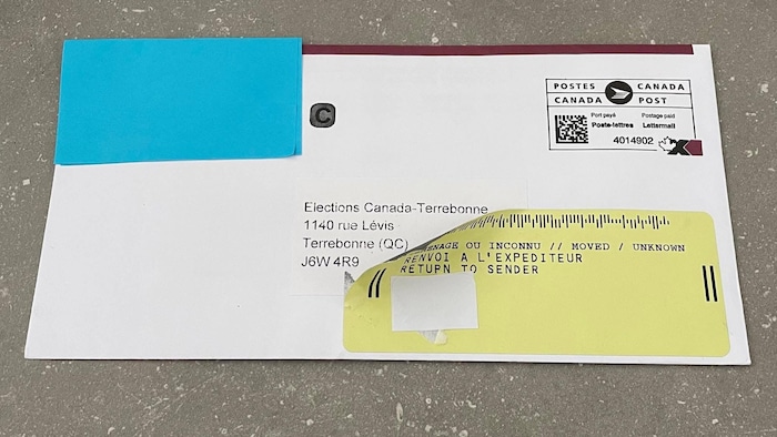 Une enveloppe avec un collant de renvoi à l'expéditeur est posée sur une table.