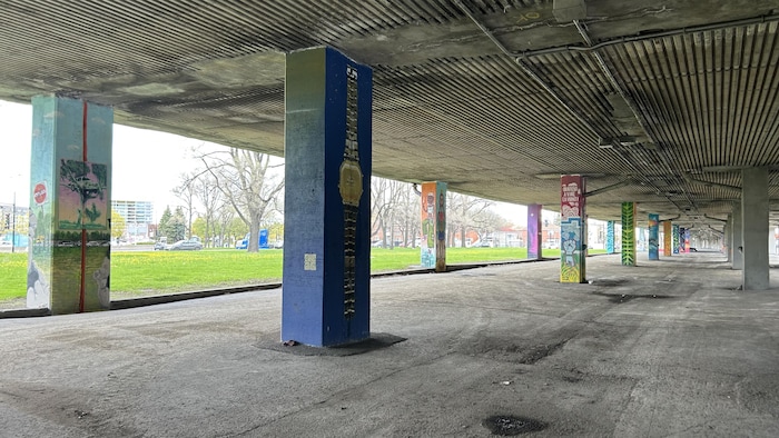 Des colonnes sont peintes sur les poutres qui soutiennent l'autoroute métropolitaine.