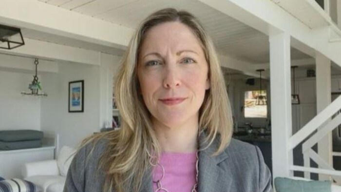 Lisa Barrett, médecin, devant un salon en blanc.