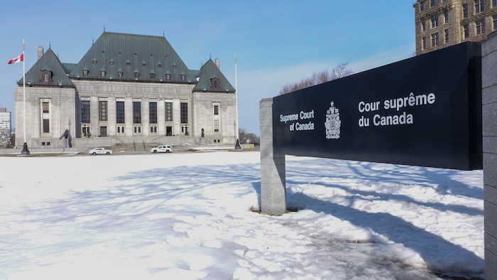 لافتة باللغتيْن الفرنسية والإنكليزية تفيد بأنّ المبنى الذي في عمق الصورة هو مقر محكمة كندا العليا.
