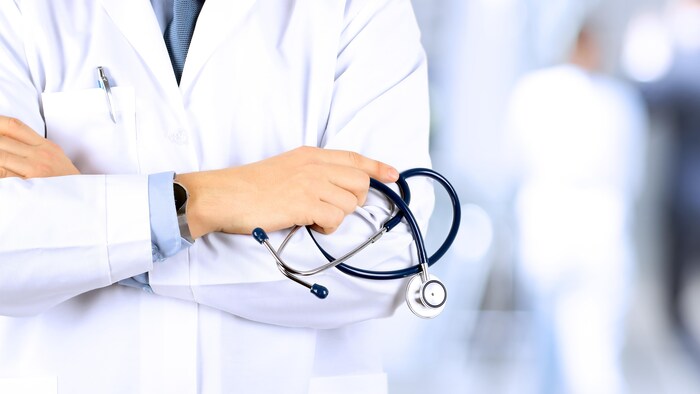 Un médecin tient un stéthoscope.