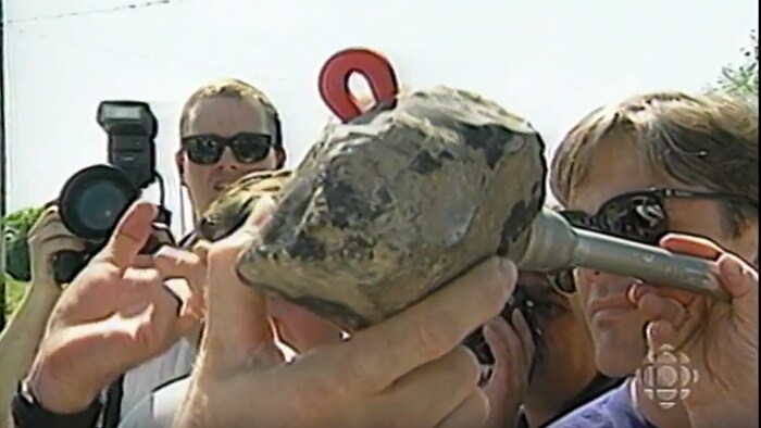 Une main montre aux journalistes la météorite qui est tombée à Saint-Robert, près de Sorel, le 14 juin 1994. 