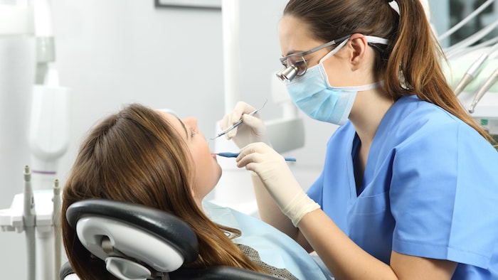 Une hygiéniste dentaire fait l'évaluation de la dentition d'une patiente.