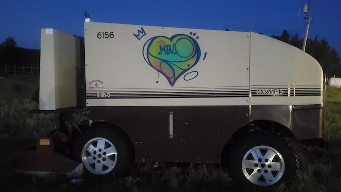 Un zamboni avec un tag d'artiste en graffiti sur le côté.