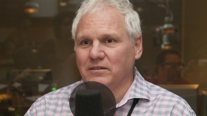 Le chroniqueur Alain Pronkin devant un micro du studio 18 de Radio-Canada à Montréal.