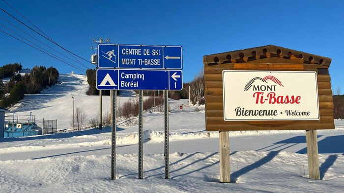 Une pancarte du Mont Ti-Basse se trouve devant la montagne.