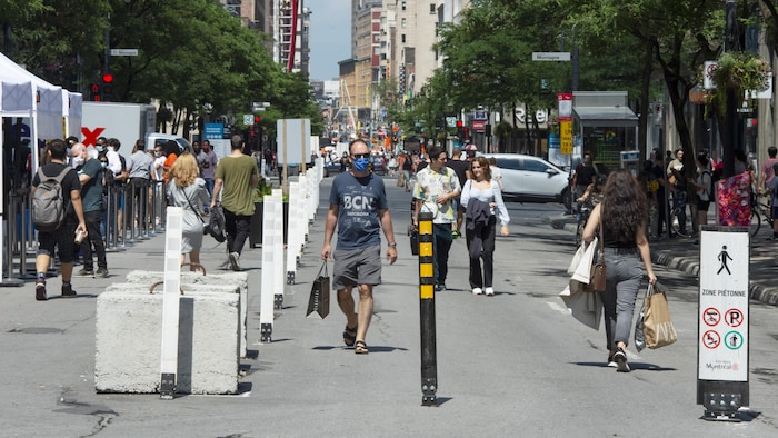 Des gens marchent sur la rue Sainte-Catherine, qui est piétonne.