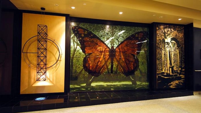 Trois tableaux dont un central qui représente un papillon.