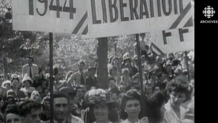 Des Parisiens brandissent des pancartes célébrant la libération de Paris le 25 août 1944.