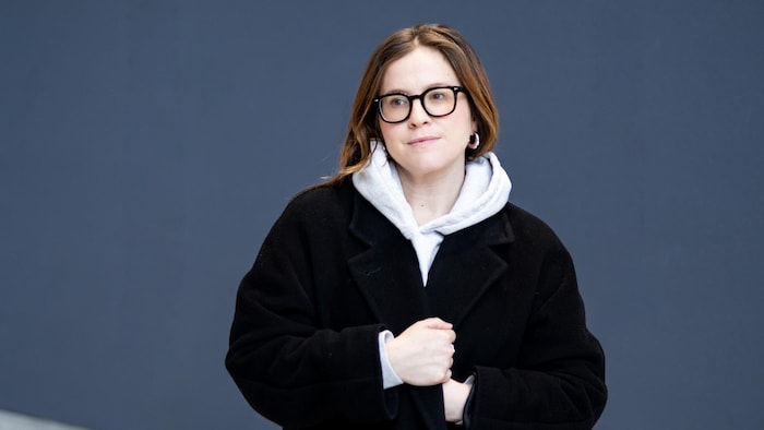 Portrait de Pascale Renaud-Hébert qui regarde de côté et a les mains accrochées à lad manteau.
