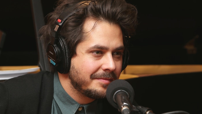 Photo de Matt Holubowski devant un micro de radio.