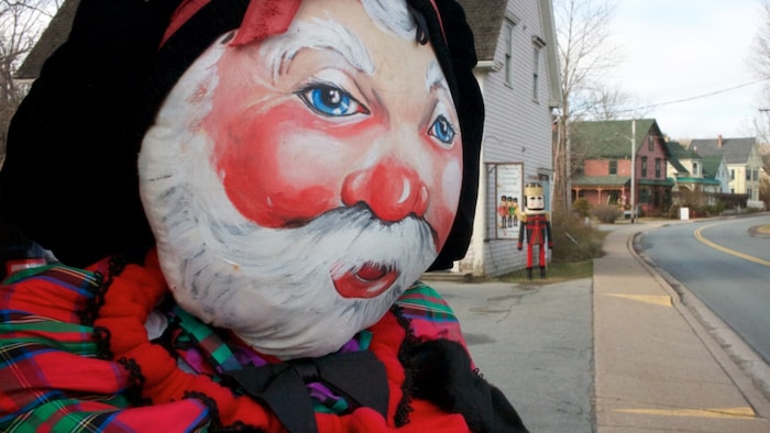 À chaque coin de rue de Mahone Bay en Nouvelle-Écosse, le père Noël observe les passants. Sur la photo, un père Noël dont le visage est peint fait face à la rue.