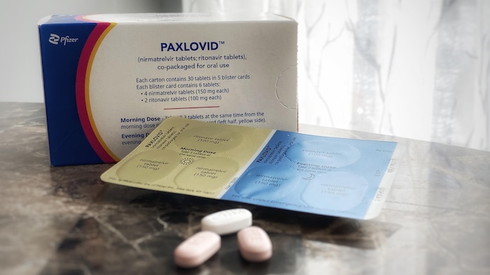 Une boîte et des pilules de Paxlovid sur un comptoir. 