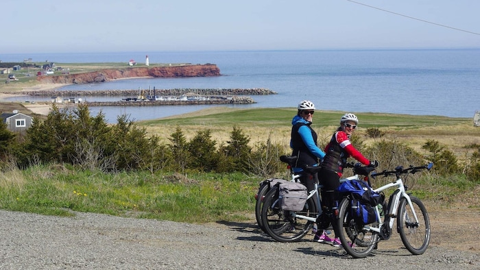 Deux cyclistes aux Îles-de-la-Madeleine.