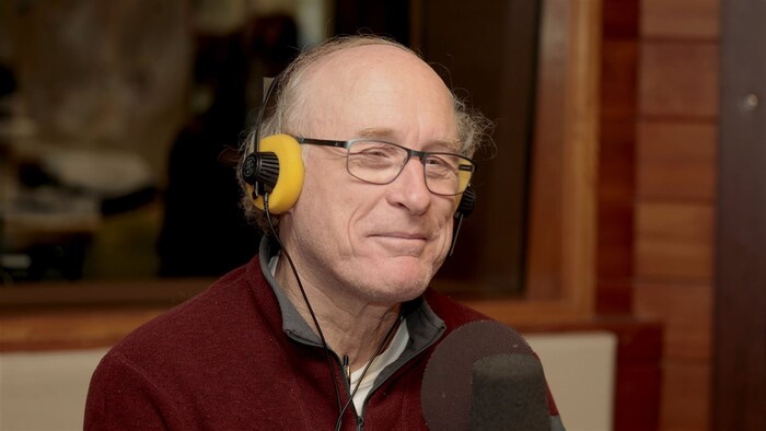 Michel Coulombe, souriant, au micro de Radio-Canada. Il porte des écouteurs.