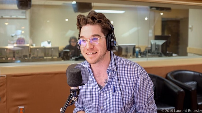 Jean-François Daoust devant un micro pendant une entrevue dans un studio radio.