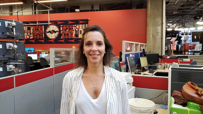 Jeune trentenaire souriante dans une salle de nouvelles