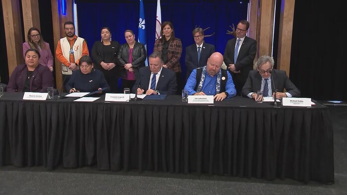 Des représentants du gouvernement et de la communauté innue de Pessamit signent un traité. 