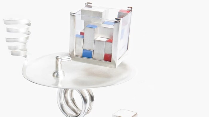 Bague en argent à plusieurs éléments dont un ressort et un cube dans lequel entrent plusieurs petits cubes.